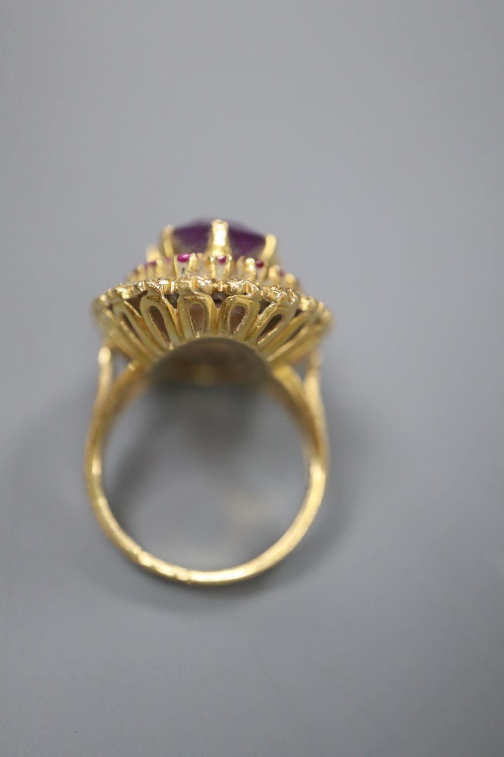 A yellow metal, amethyst, ruby and rose cut diamond set oval dress ring, with diamond set shoulders, size M